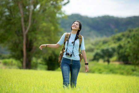 Asian young woman holding camera and standing in the jungle adventure.  Tourism for destination and leisure trips for education and relax in nature park.  Travel vacations and Lifestyle Conceptの写真素材
