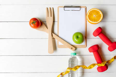 Planning for Diet Health eat and food.  Sport exercise equipment workout with fresh fruit, measuring tap, note pad for fitness style. Nutrition Healthy Lifestyle Concept, Top view and copy spaceの写真素材