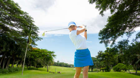 Golfer sport course golf ball fairway. People lifestyle woman playing game golf tee of blue sky background. Asia female player game shot in summer. Healthy and Sport outdoorの写真素材