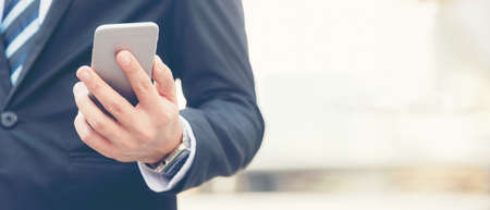 Close up hand Businessman using smart phone communication him work.  People partner man check data financial in tablet computer.  Business and Technology Concept. copy space for bannerの写真素材
