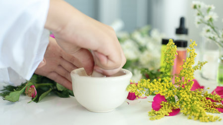 Close up hands woman science lab research for Natural alternative herb and essential oil from fresh flower new product skin care with microscope in laboratory.  Healthy herb Conceptの写真素材