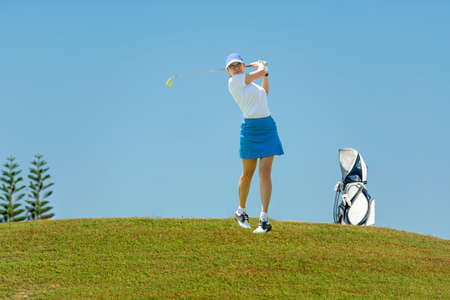 Golfer sport course golf ball fairway. People lifestyle woman playing game golf tee of blue sky background. Asia female player game shot in summer. Healthy and Sport outdoorの写真素材