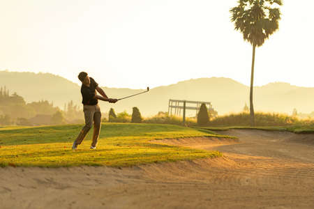 Golfer sport course golf ball fairway.Â  People lifestyle man playing game golf tee off on the green grass.Â  Asian man player game shot in summer, sunlight background.  Healthy and Sport outdoorの写真素材