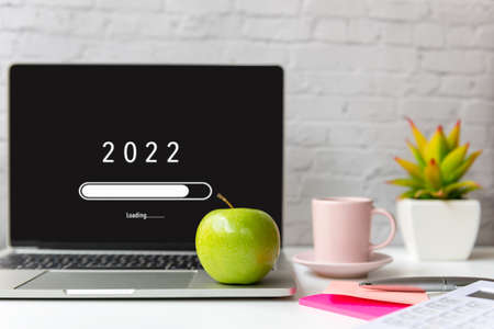 Loading year 2022 for start new business and new life. Healthy snack with working in office.  Green apple and fresh water for diet Health Planningの写真素材