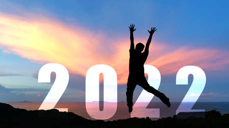 Silhouette happy man jumping congratulation and celebrate in Happy New year 2022 for change new life future concept. Freedom lifestyle group people team jump as part of Number 2022 success at the sunset beach outdoorの写真素材