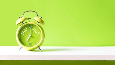 2021 and 2022 on black alarm clock on wooden table with copy space , Merry Christmas and Happy new year concept. Copy space and banner for textの写真素材