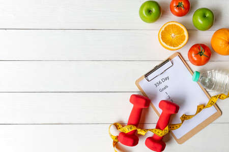 New Year for New Changes Healthy 2022 timing 365 day.  Fresh vegetable fruits and healthy food for sport equipment for women diet slimming weight loss on white wood.  Healthy and Holiday Conceptの写真素材