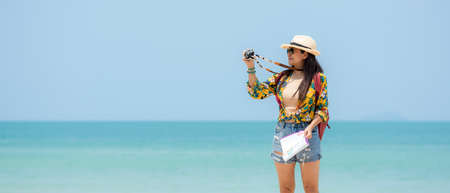 Happy traveler and tourism women travel summer on the beach.Â  Asia smiling people holding map and camera take photo  and relax outdoor for destination and leisure trip travel in holiday.Â  Summer Vacation Travel Conceptの写真素材