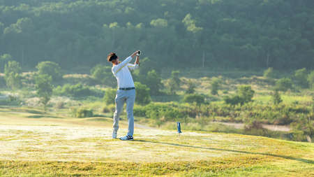Golfer sport course golf ball fairway.Â  People lifestyle man playing game golf tee off on the green grass.Â  Asian man player game shot in summer.Â  Healthy and Sport outdoorの写真素材
