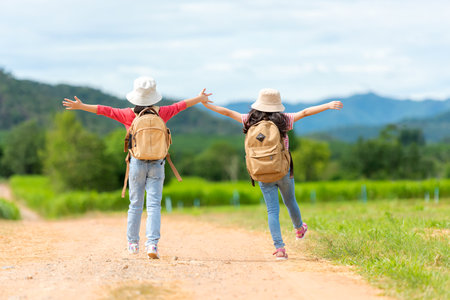 Asian girl raise arms and jumping on the green meadow outdoors adventure. People kid tourism  traveling education nature forest for destination and leisure trips with mountain.Â  Travel vacations and Life Conceptの写真素材