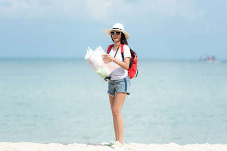 Happy traveler and tourism young women travel summer on the beach.Â  Asian smiling people holding map and camera take photo  and relax outdoor for destination and leisure trip travel in holiday.Â  Summer Vacation Travel Conceptの写真素材