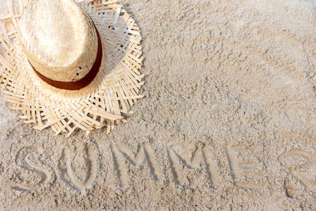Summer Travel.  Writing summer on the sand beach with vintage hat for  relax on the beautiful beach and blue sky background, copy space. Travel and Summer Conceptの写真素材