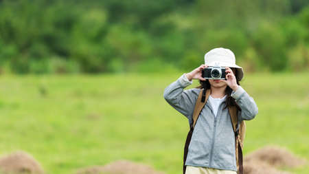 Asian girl woman take a photo and checking camera. People tourism travel destination leisure trips for education relax outdoors adventure forest nature. Travel vacations Concept, copy space for bannerの写真素材