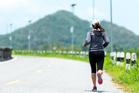 Healthy woman jogging run and workout on road outdoor. Asian runner people exercise gym with fitness session. Healthy and Lifestyle Concept.の写真素材