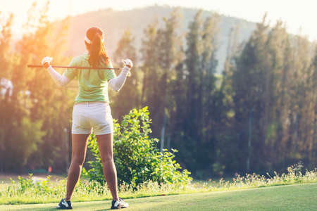Golfer sport course golf ball fairway. People lifestyle woman relax after swing golf ball on the green.  Asia female player game shot in summer. Healthy and Sport outdoorの写真素材