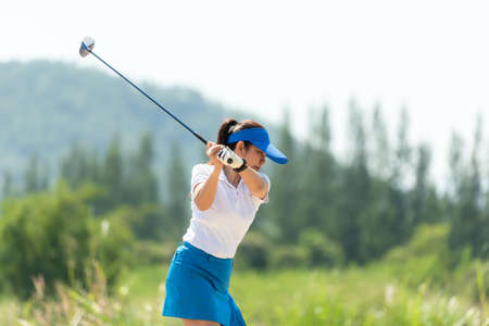 Golfer sport approach on course golf ball fairway.Â  People lifestyle woman playing game golf tee of on the green grass.Â  Asia female player game shot in summer.Â  Healthy and Sport outdoorの写真素材