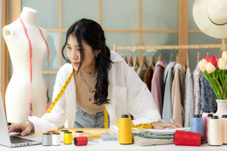 Asian young women fashion designer  working on her designer in the showroom,  Lifestyle Stylish...