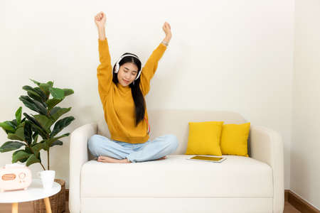 Young smiling women chill & relax raise arm after working and meeting at home.  Lifestyle freelance happy and drinking coffee in luxury living room in vacation holiday and summer day.  Lifestyle Conceptの写真素材