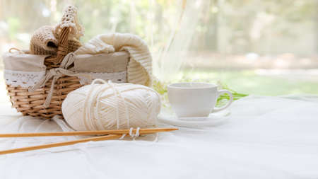 Coffee morning.  Yellow steaming cup of hot coffee for relax after working hobbies crochet on white wooden near windowの写真素材