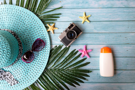 Summer Fashion woman big hat and sunblock with accessories item, vintage camera go to travel in the beach. Tourism travel on holiday happy leisure and destination trip.  wood blue background. Summer and Travel Conceptの写真素材
