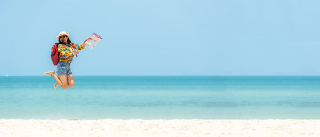 Happy traveler and tourism women travel summer on the beach.Â  Asian people jumping  holding map and camera planning travel trip and relax outdoor for destination and leisure.Â  Copy space for banner, Summer Vacation Travel Conceptの写真素材
