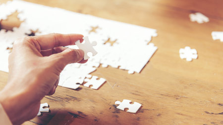 Close up Business people holding jigsaw connecting couple puzzle piece for matching to goals target....