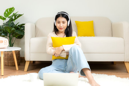 Young smiling woman happy watching movies and  chill relax in summer holiday. Lifestyle girl using laptop for entertainment in living room at home.  Lifestyle Conceptの写真素材