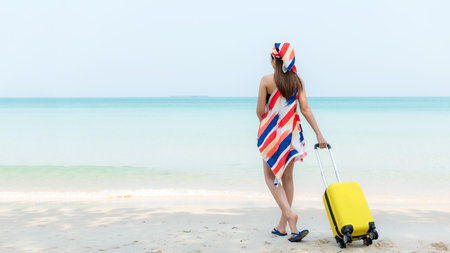 Summer vacations. Lifestyle  woman relax and chill on beach background.  Asia happy young people walking with bag travel suitcase luggage fashion dress.  Summer trips travelの写真素材