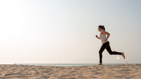 Athletic woman jogging exercise and relax and freedom on sand beach. People running and workout.  Lifestyle and Healthy Concept.  Copy space for textの写真素材