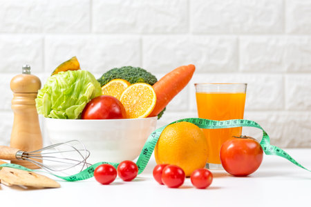 Select focus. Diet and healthy fresh vegetable fruits for detox body slim fit for health lifestyle with Sport exercise equipment workout and orange juice,  white background. Weight Loss and Diet Conceptの写真素材