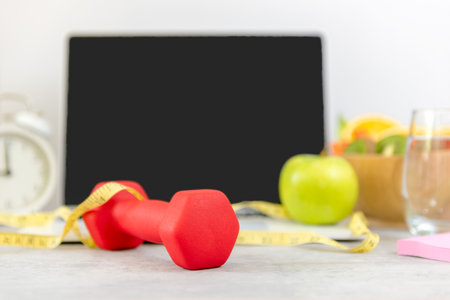 Close up dumbbell.  Healthy snack for diet planning for working in office.  Fresh  fruit with green fruit and tape measure Laptop background.  Healthy Lifestyle Conceptの写真素材