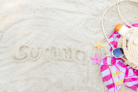 Summer items fashion tourism woman swimsuit Bikini with sunblock. Traveler Travel tour and vacations trip in the holiday on sand beach background, top view. Summer and Travel Conceptの写真素材