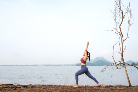 Lifestyle woman worm up raise arm before pose for healthy life. Young people yoga exercise and pose balance body vital zen and meditation workout and fitness sport outdoor in sunny dayの写真素材