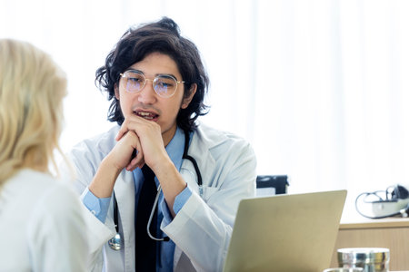Doctor talking and discussing something with patient in the hospitalの写真素材