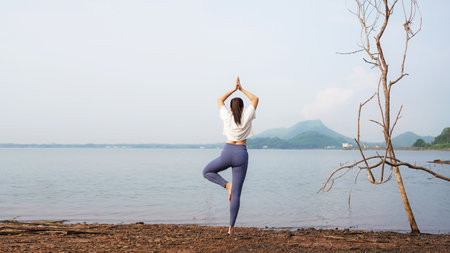 Lifestyle woman yoga exercise and pose for healthy life. Young girl or people pose balance body vital zen and meditation for workout nature park background. Copy space for banner. Healthy Conceptの写真素材