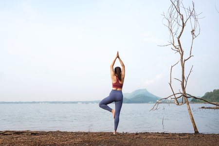Lifestyle woman worm up raise arm before pose for healthy life. Young people yoga exercise and pose balance body vital zen and meditation workout and fitness sport outdoor in sunny dayの写真素材