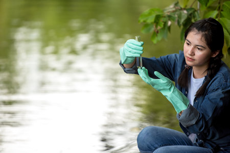 Asian student biology taking and testing sample of natural river water. Experts science women keep water for research analysis in the laboratory. Environmental pollution Conceptの写真素材