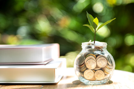 Plant growing in Coins glass jar for education together and success.  Saving money planning future education. Green nature background, copy spaceの写真素材