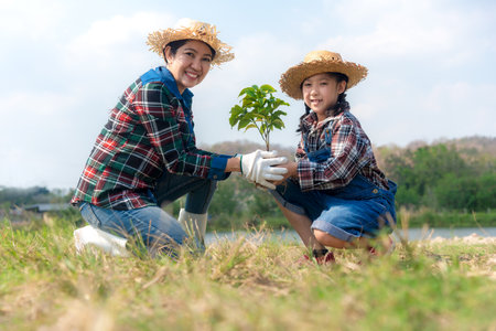 Asian family mom and kid daughter plant sapling tree outdoors in nature spring for reduce global warming growth feature and take care nature earth. Environment Conceptの写真素材