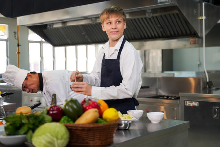 Chef teacher teaches cooking to the group children in class kitchen room.  Chef preparing student for learning marking and cooking food at workshop.  Education Conceptの写真素材