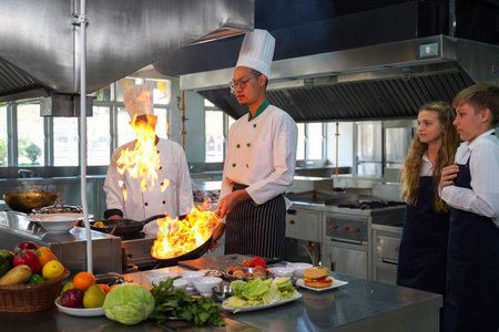 Chef teacher teaches cooking to the group children in class kitchen room.  Chef preparing student for learning marking and cooking food at workshop.  Education Conceptの写真素材
