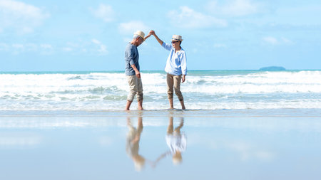 Asian Lifestyle senior couple walking and dancing chill on the beach happy in love romantic and relax time after retirement.Â  People tourism elderly family travel leisureの写真素材