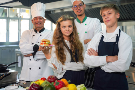 Chef teacher teaches cooking to the group children in class kitchen room.  Chef preparing student for learning marking and cooking food at workshop.  Education Conceptの写真素材