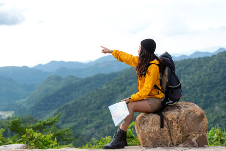 Woman travel hiker adventure on mountain nature landscape. Asia people lifestyle tourist girl backpack pointing find directions explore and camping outdoors for relax summer timeの写真素材