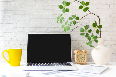 Business workplace with laptop and graphs finance diagrams and yellow cup coffee drink. White background.  Business Object Conceptの写真素材