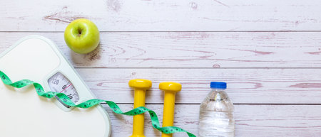 Diet and Healthy life loss weight Concept. Green apple and Weight scale measure tap with fresh vegetable and sport equipment for women diet slimmingの写真素材