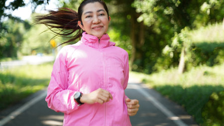 Healthy woman jogging run and workout on road outdoor. Asian runner people exercise gym with fitness session, nature park background. Health and Lifestyle Conceptの写真素材