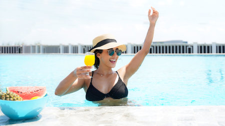 Summer time and Vacations. Women lifestyle relaxing and drinking juice orange and eating watermelon so happy in luxury swimming pool sunbath, summer day at the beach resortの写真素材
