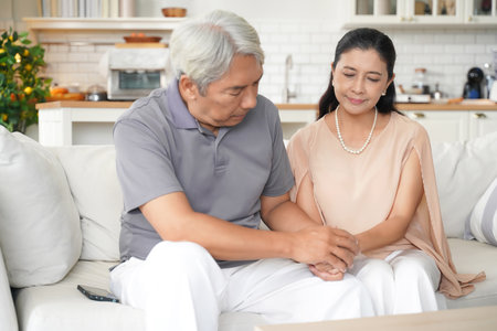 Asia senior elderly man comforting and hold hands him wife after having problems relationship.Â  Family after elderly concerned about healthy care.Â  Family and Health care Conceptの写真素材