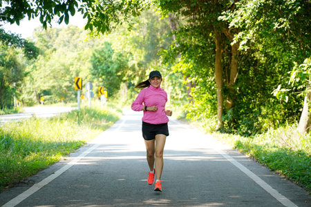 Healthy woman jogging run and workout on road outdoor. Asian runner people exercise gym with fitness session, nature park background. Health and Lifestyle Conceptの写真素材